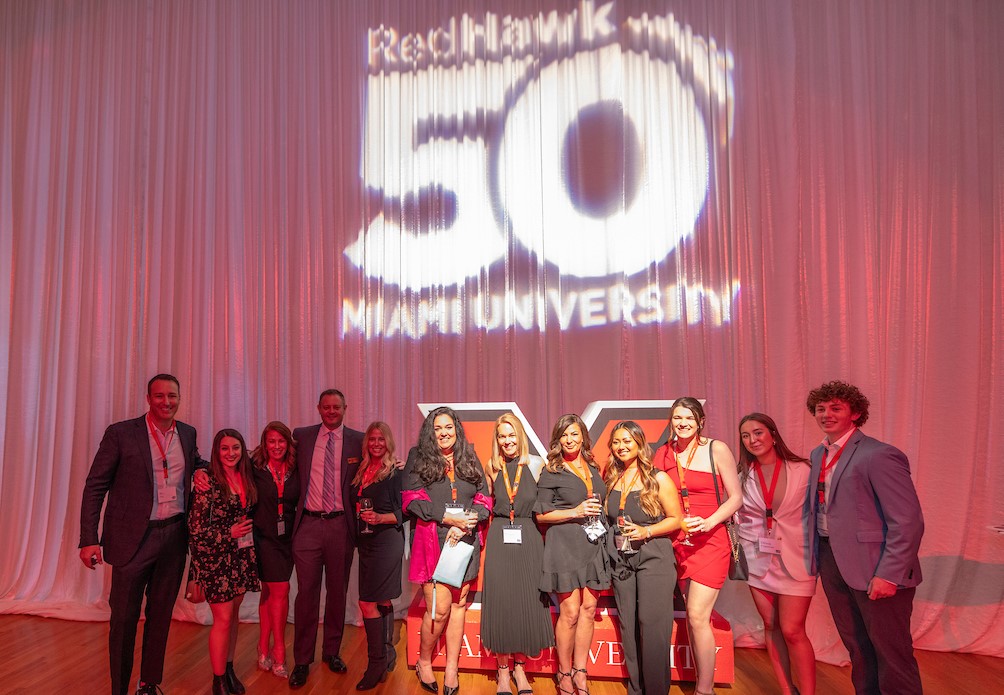Several award winners of the RedHawk50 gather under a huge spotlight during the gala