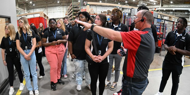 group photo of students taking tour of factory