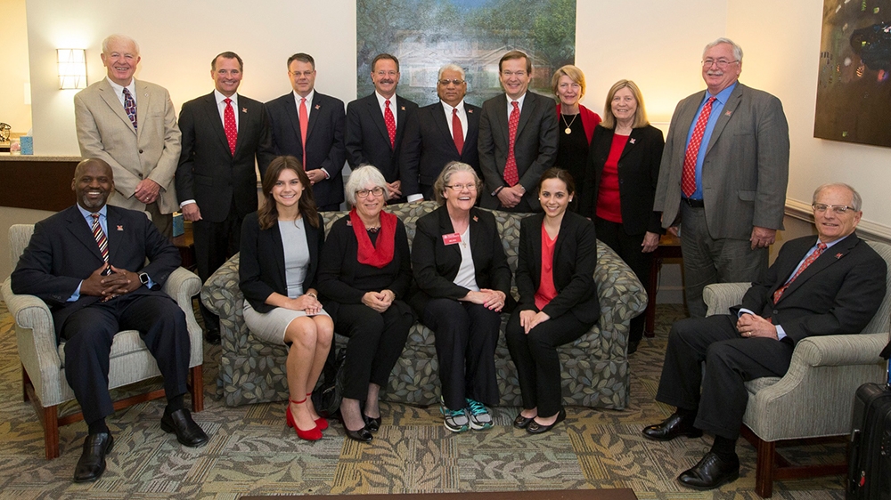 The board of trustees standing and seated.
