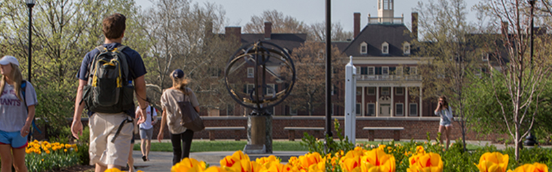 Students walking on campus with the Sundial and MacCracken Hall in the background