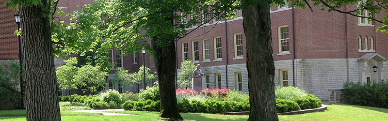 The grassy courtyard of historical McGuffey Hall on a sunny day