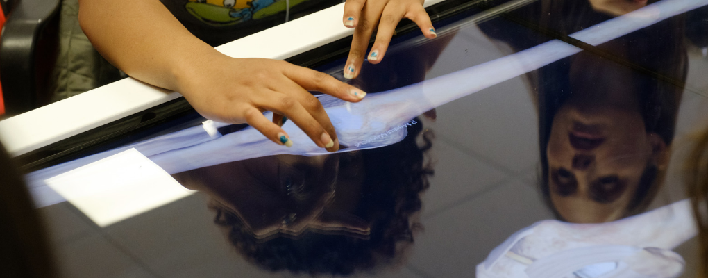 A student touches a table showing a virtual cadaver