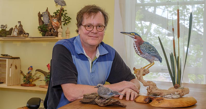 Mike Wright, instructor of biology, with models of a mourning dove fledgllng (left) and a green heron in his studio at the Oxford Community Arts Center (photos by Scott Kissell). 