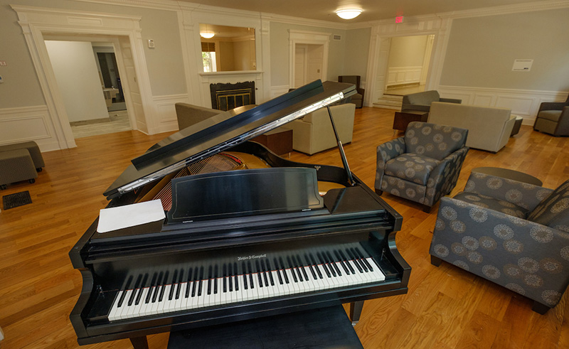 Hamilton Hall's living room features refinished hardwood floors and original woodwork.