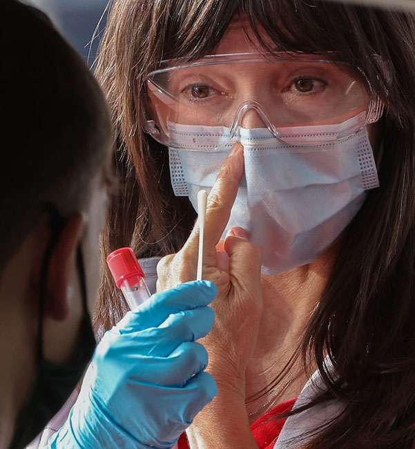 nurse doing a covid test on a student