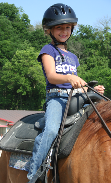 Child participating in summer equestrian camps.