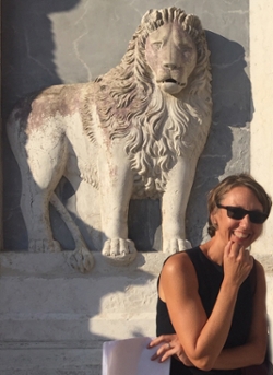 Cynthia Klestinec standing by a lion sculpture