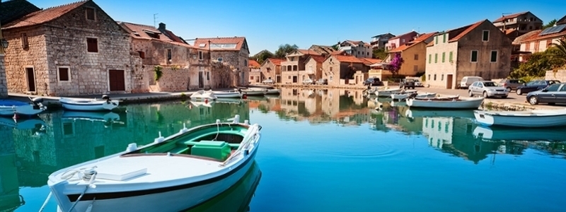 Beautiful coastline of Croatia, old buildings and a boat.
