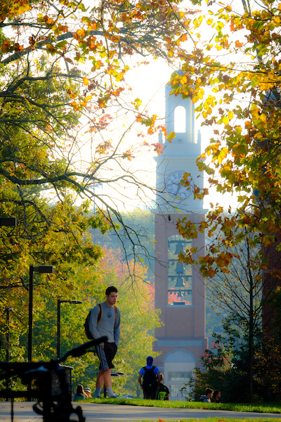 Student walking on campus in fall.