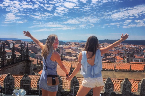 Two students looking out over city from a rooftop in Spain