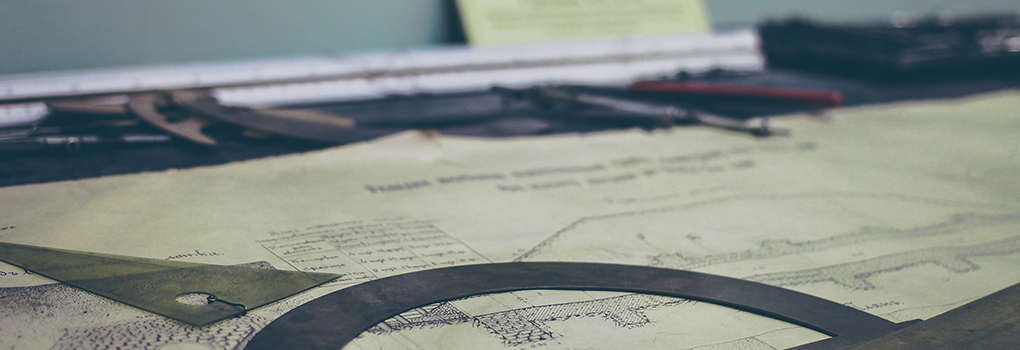 A set of blueprints is surrounded by architectural tools