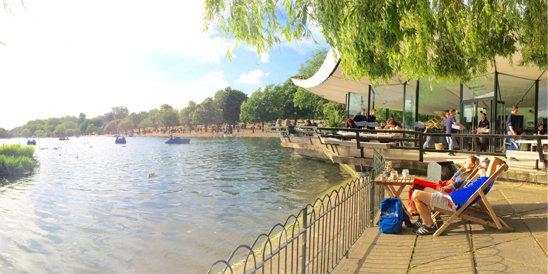 People lounge in deck chairs at the serpentine pond in London