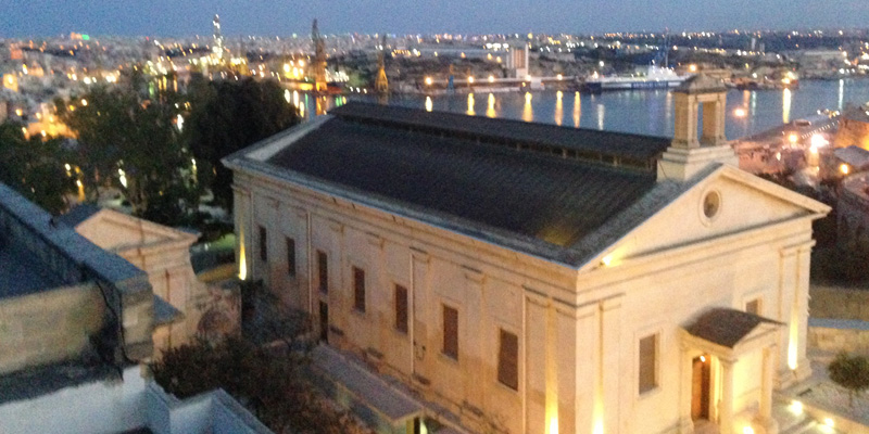 A nighttime shot of buildings and water in Malta