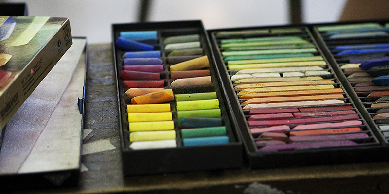 A box full of colorful pastel crayons