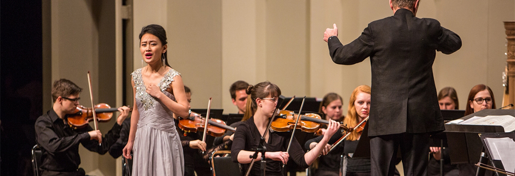 A soloist performs with the symphony orchestra at Hall Auditorium during a Chinese New Year concert