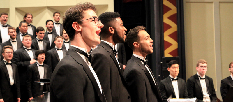 Side view of 3 male soloists at a Glee Club concert