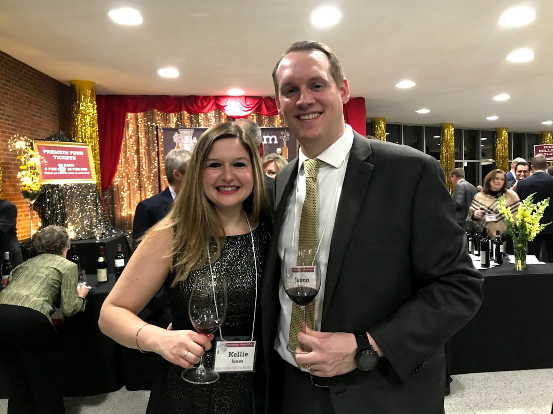 A smiling woman and man hold their glasses