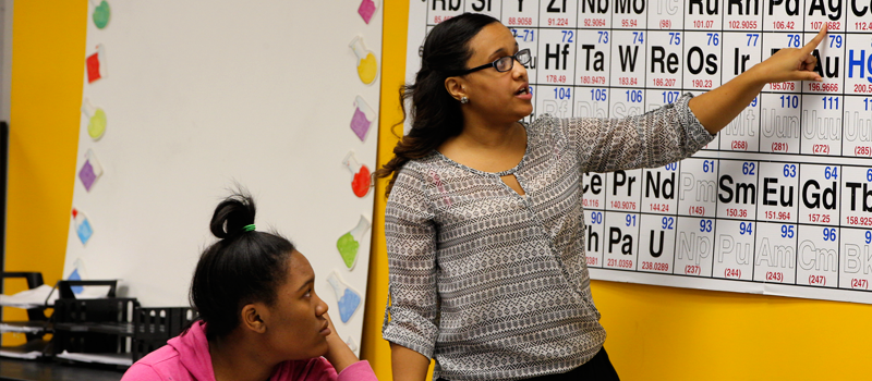 teacher pointing to periodic table