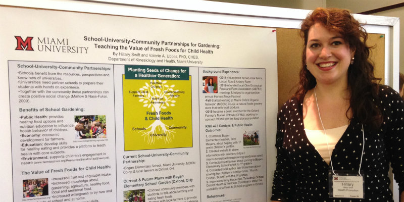 student presenting research poster at conference