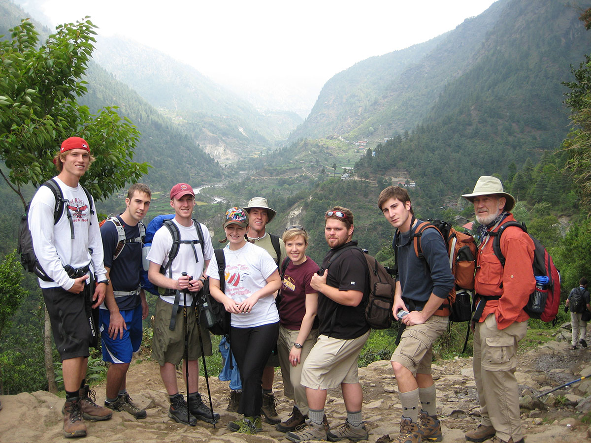 A student group posing while hiking on a mountain range