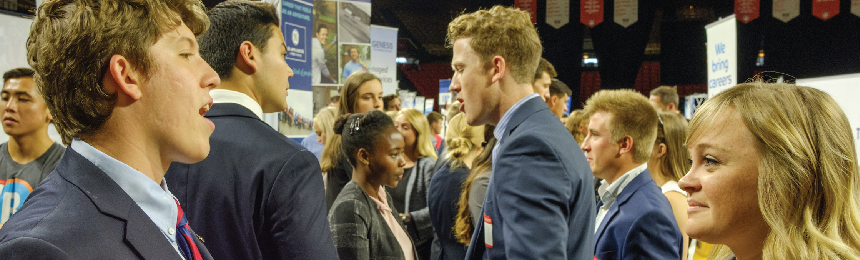 Woman and man speak in foreground while other pairs speak behind them.