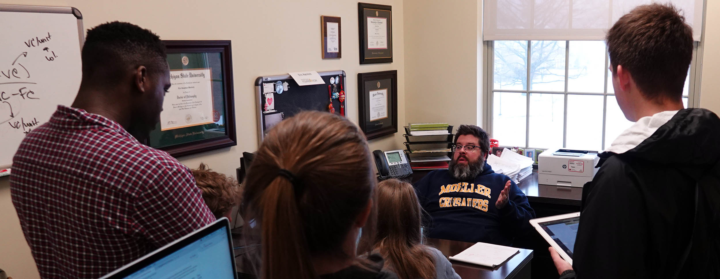 Eric Maranich talks with students in his office