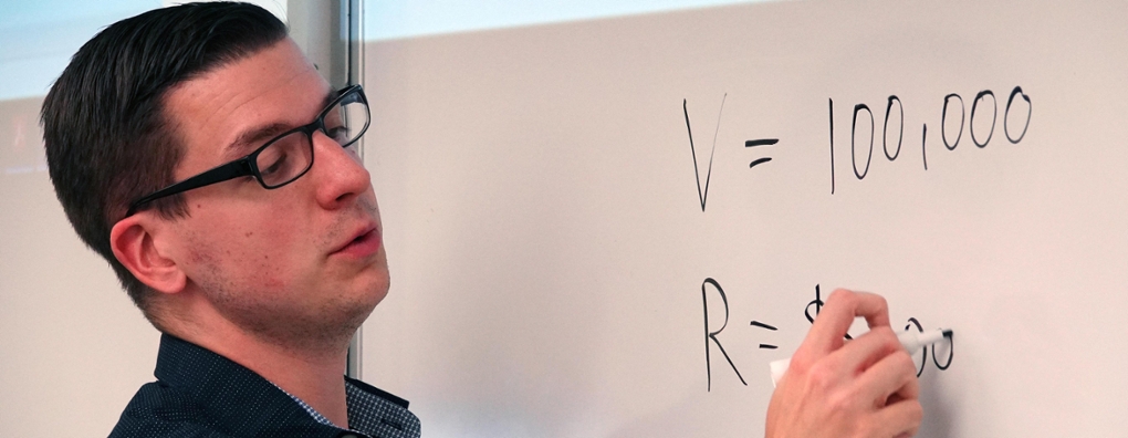 Mark Tremblay writing on a whiteboard