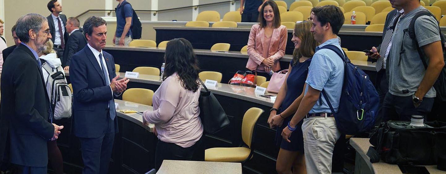 Students wait to talk to a guest finance speaker in Taylor Auditorium