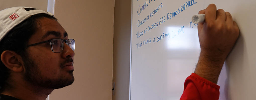 Student writes on whiteboard in class