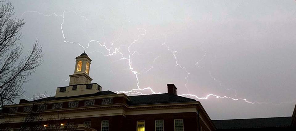 Lightning crackles over the top of the Farmer School