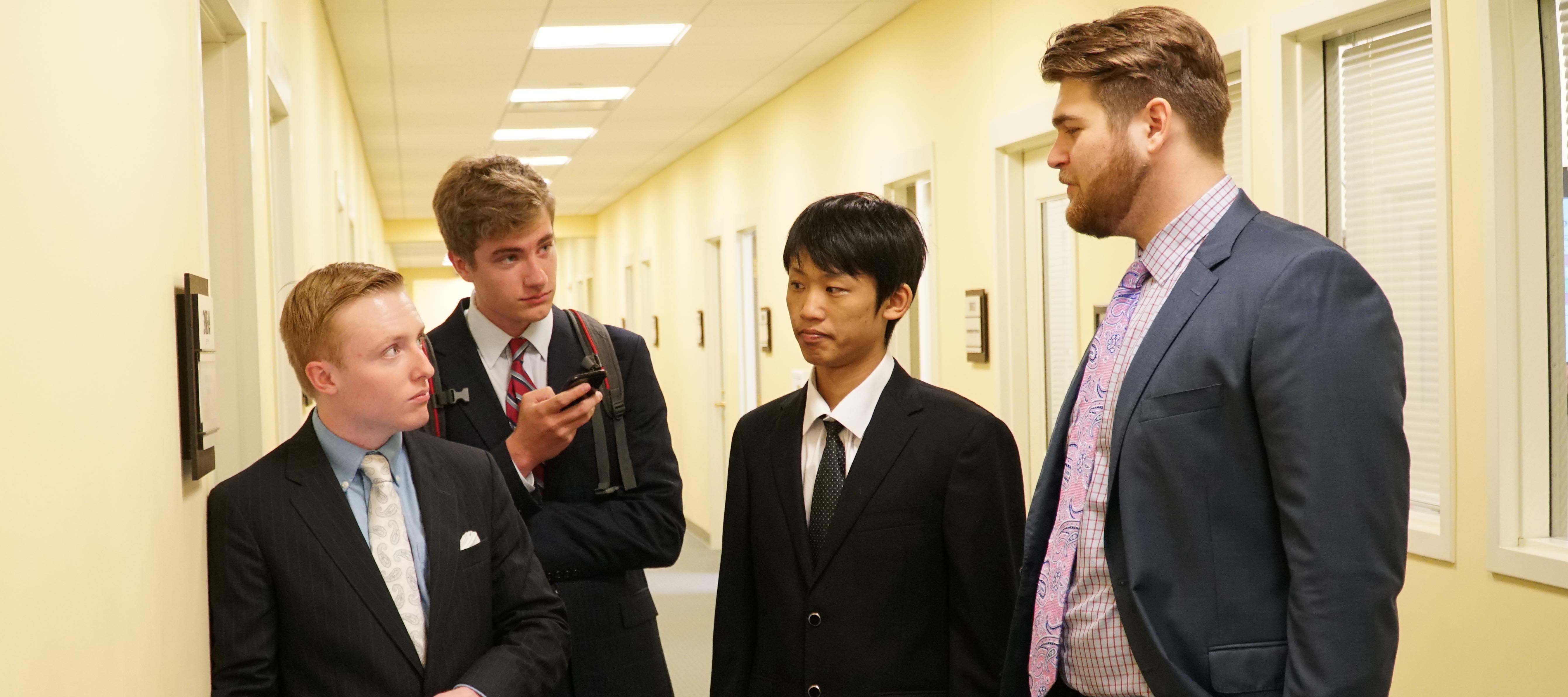 Students stand in hall before presentation