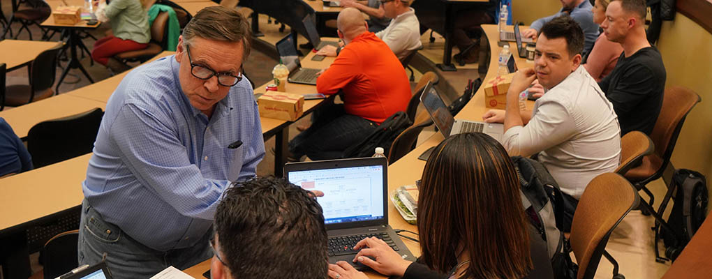 Teacher talks with students during MBA class