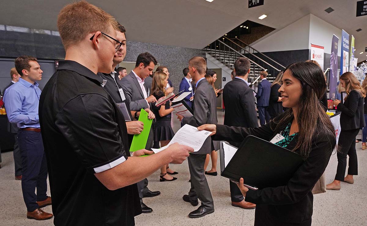 Student hands resume to recruiter at Career Fair