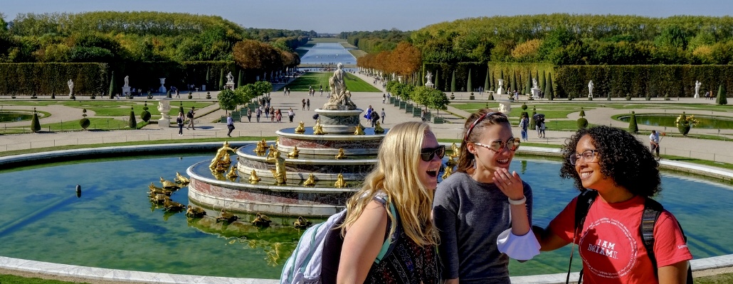 three Miami students laughing and smiling as they are studying abroad in Paris at the Castle of Versailles