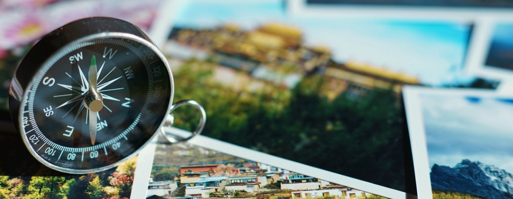 Compass on blur colorful photograph of popular toustist destination background