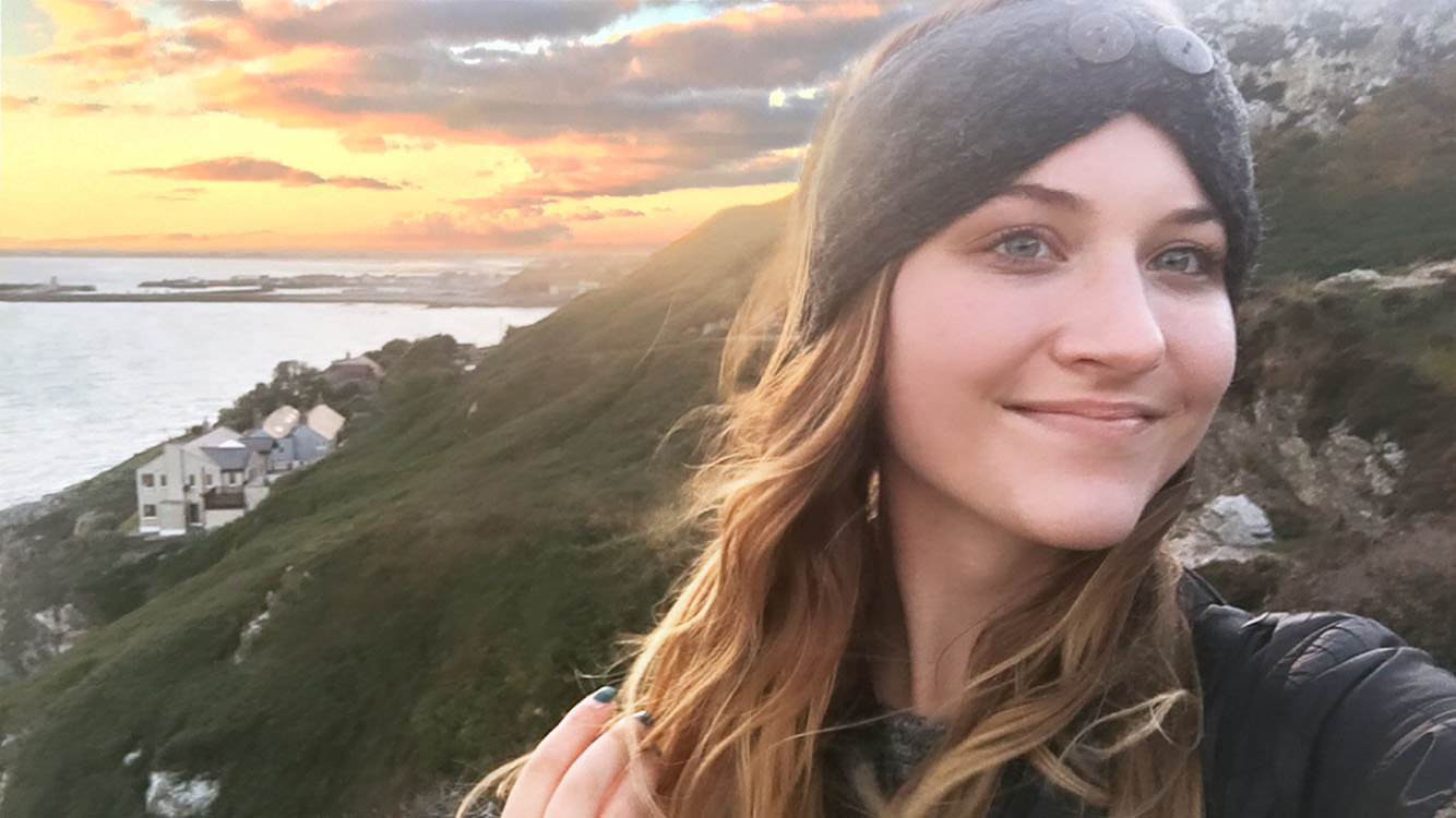 girl takes a selfie in front of a cliff