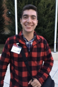A boy wearing a plaid shirt poses for a picture