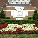 A block M made of flowers in front of Pearson Hall