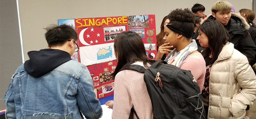 Students looking at a poster that was developed by an ELC student.
