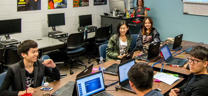 ELC students sitting in a classroom with computers.