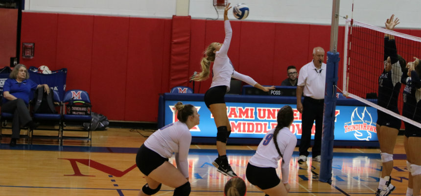 Miami Middletown volleyball team spiking the ball