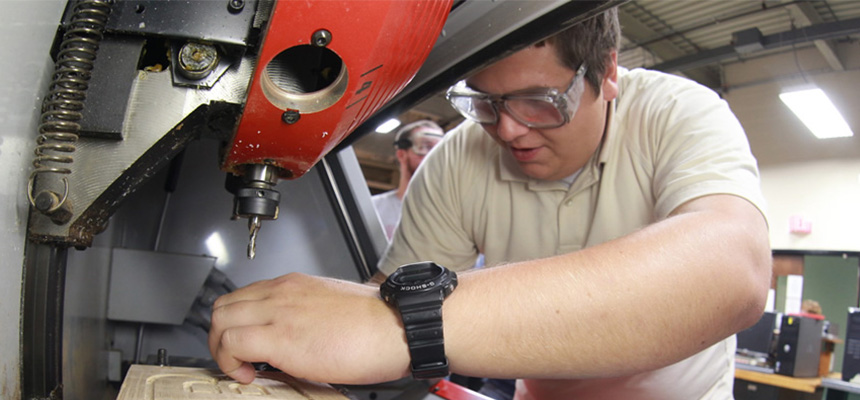 A male student working on a piece of engineering equipment