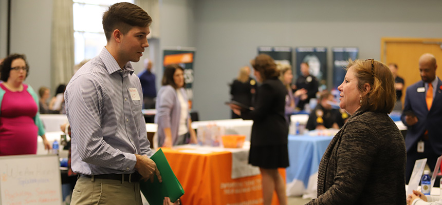 Male student speaking to female at career fair