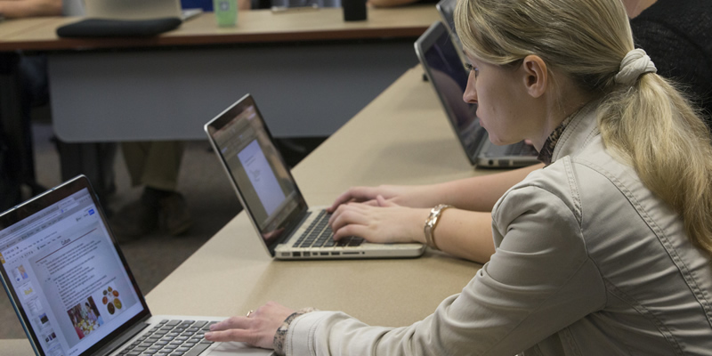 A student working on an assignment on her laptop.