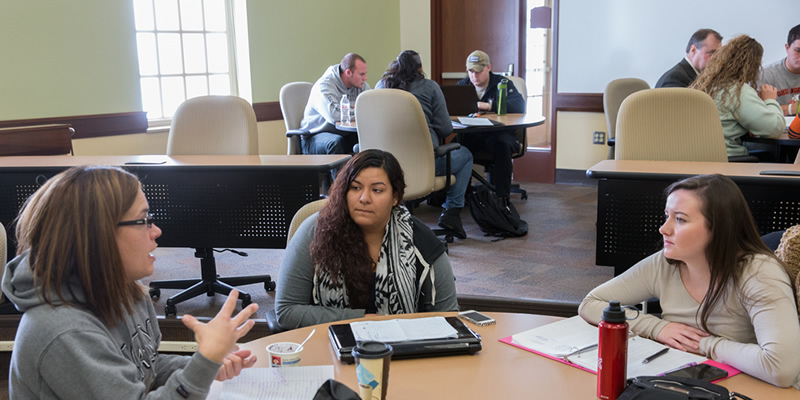 Students talking at a table during class at the Voice of America Learning Center