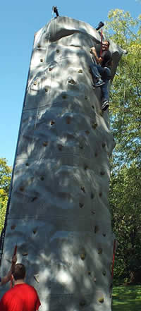 Student on a rock climbing wall in the Miami University Middletown Quad during the spring campus picnic.