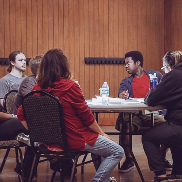 Diversity and Multicultural Students at the YMCA center sitting around a table.