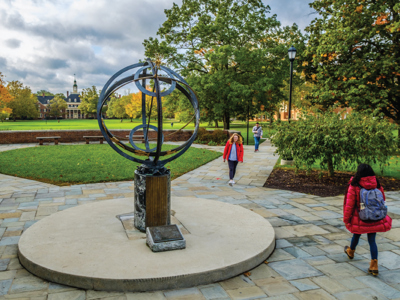 Students walking by the sundial on the Oxford campus.