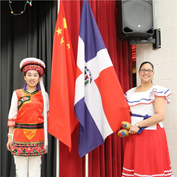Latin and Chinese students dance together at a multicultural dance festival.