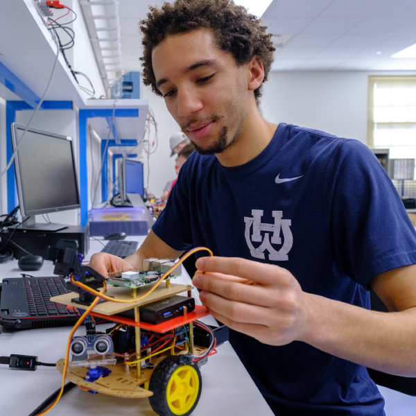 A student working on a electrical car during a lab.